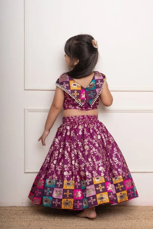 Elegant purple lehenga set with intricate golden floral motifs and multicolored patchwork accents for a festive look